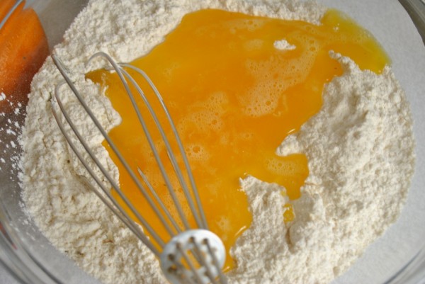 В муку добавляем яичные желтки взбитые с сахаром и солью